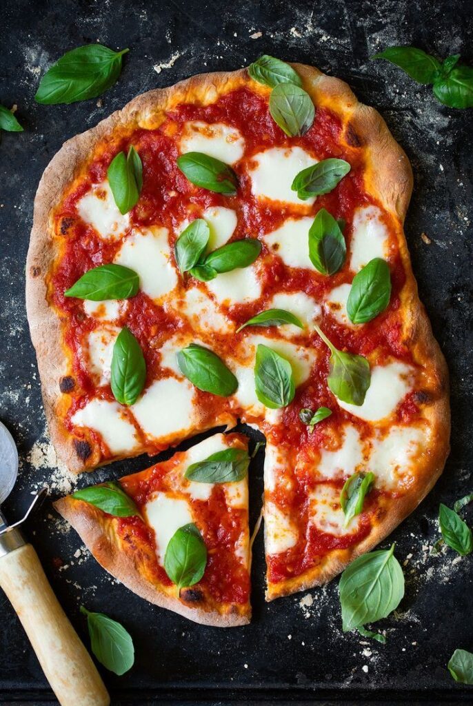 4c27b648-597e-455a-8030-2810e7d82942 - Master the Art of Homemade Pizza with Fun, Simple Steps | Margherita pizza with fresh basil, mozzarella, and tomato sauce on a rustic crust, topped with vibrant green basil leaves.