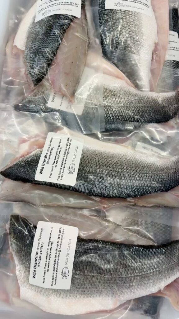 Packaged wild Branzino fish fillets on display with labels, ready for purchase and cooking.