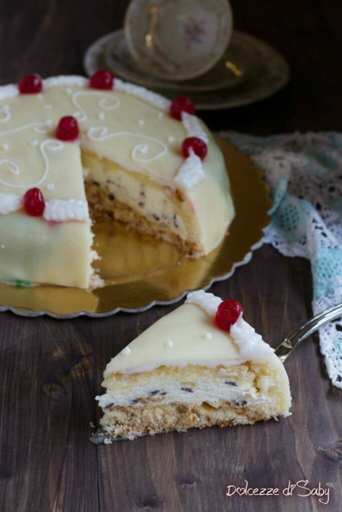 Ricotta cake with a slice served on a plate, topped with cherries and cream.