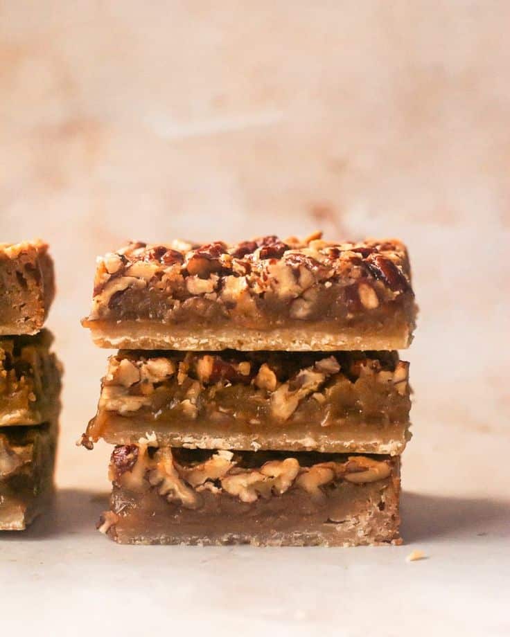 Stacked pecan bars with gooey filling and a crumbly crust, perfect for dessert lovers.