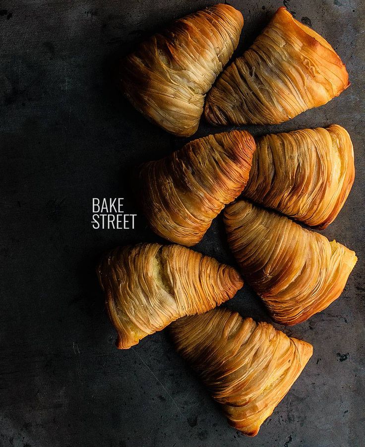 Golden crispy sfogliatelle pastries arranged on a dark surface.