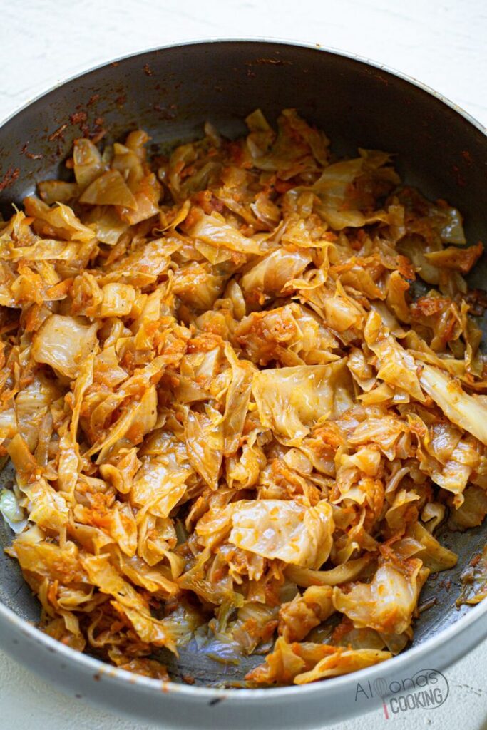 Sautéed cabbage with tomato sauce in a pan, perfect for a flavorful and healthy side dish.