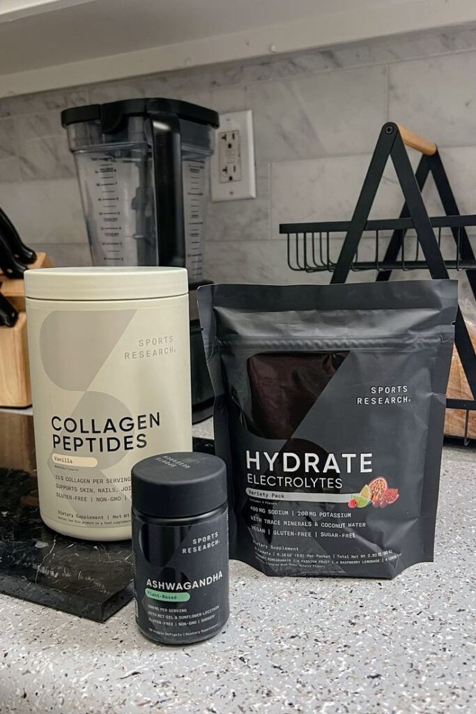 Sports supplements on kitchen counter: Collagen Peptides, Hydrate Electrolytes, and Ashwagandha by Sports Research.