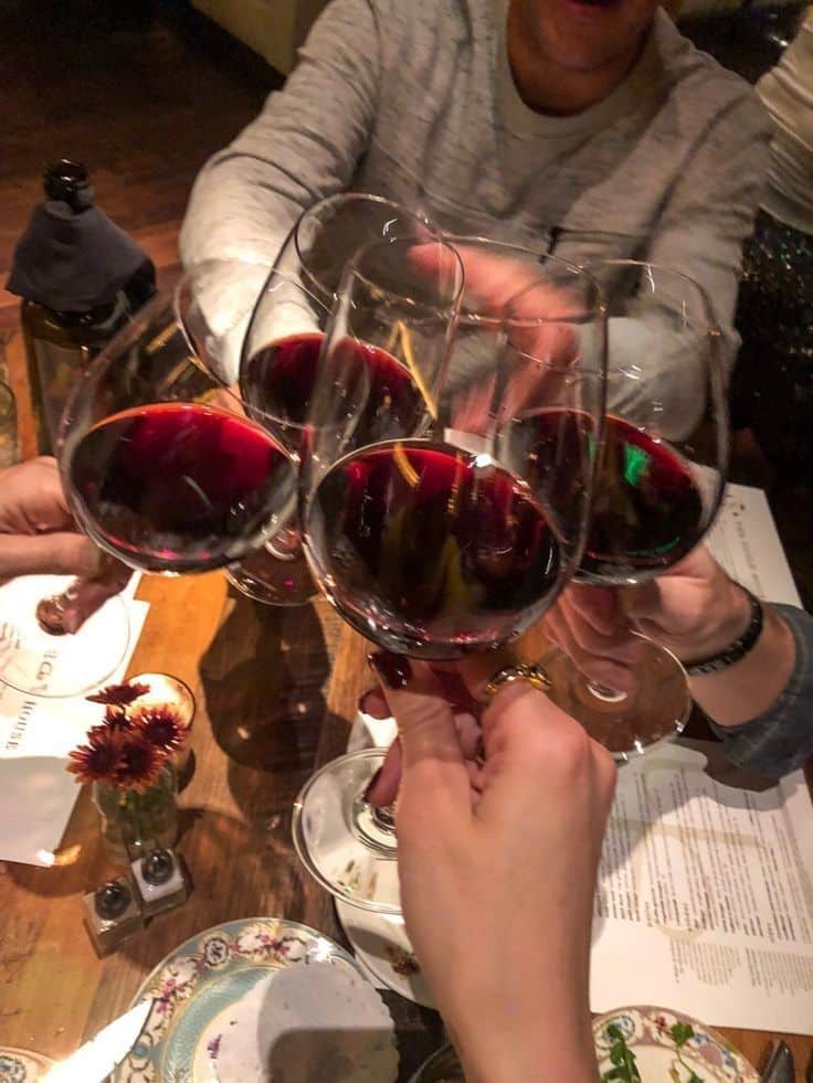 90235116-0730-48e8-b48a-b9790c851fcc - 10 Crowd-Pleasing Appetizers That Will Wow Your Party | Group toasting with red wine glasses at a cozy dinner party, creating a warm and festive atmosphere.