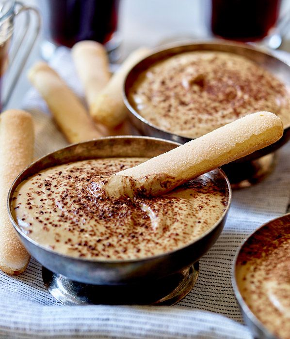 Creamy tiramisu in bowls with ladyfingers dusted with cocoa, perfect for a luxurious Italian dessert experience.
