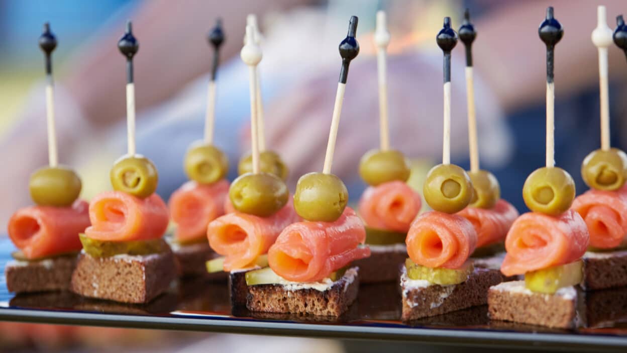 Salmon canapés with olives on skewers, perfect for gourmet appetizers or elegant party snacks.