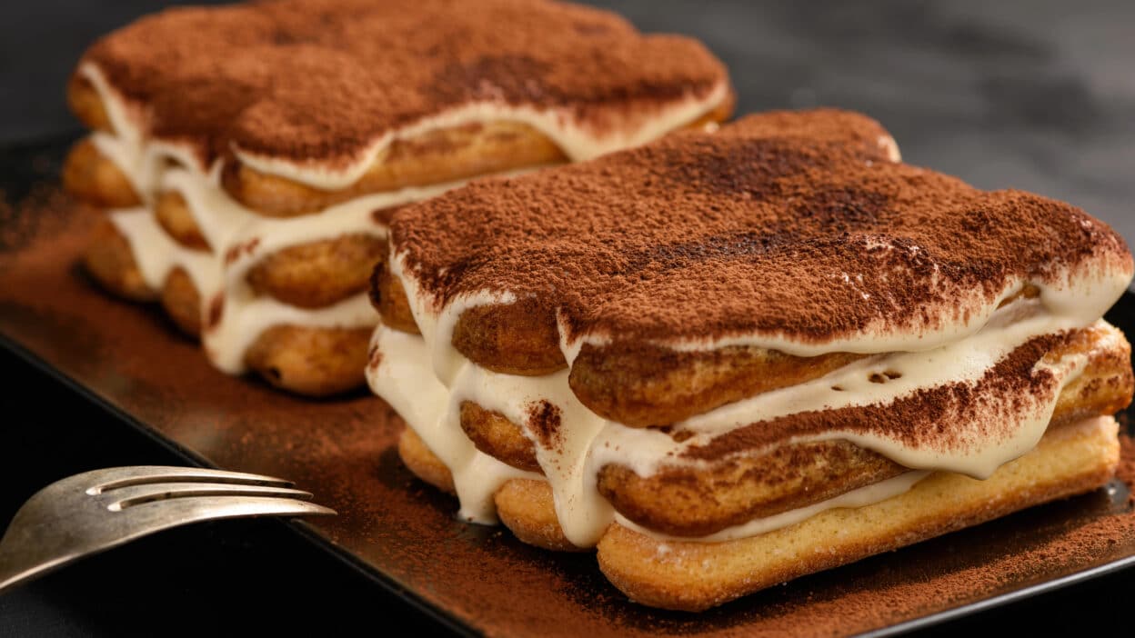 Depositphotos_186696938_XL - Indulge in the Best Tiramisu Recipes: Classic, Vegan & More| Delicious homemade tiramisu with creamy layers and cocoa powder, served on a plate with a fork.