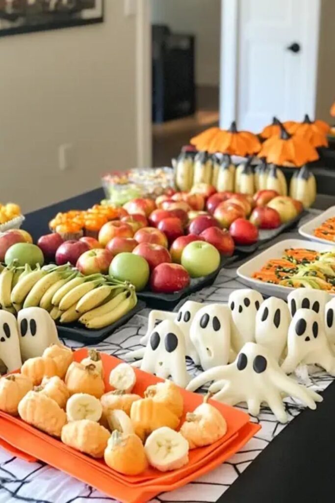 Halloween-themed fruit platter with ghost-shaped snacks, bananas, apples, and pumpkins on a festive table.