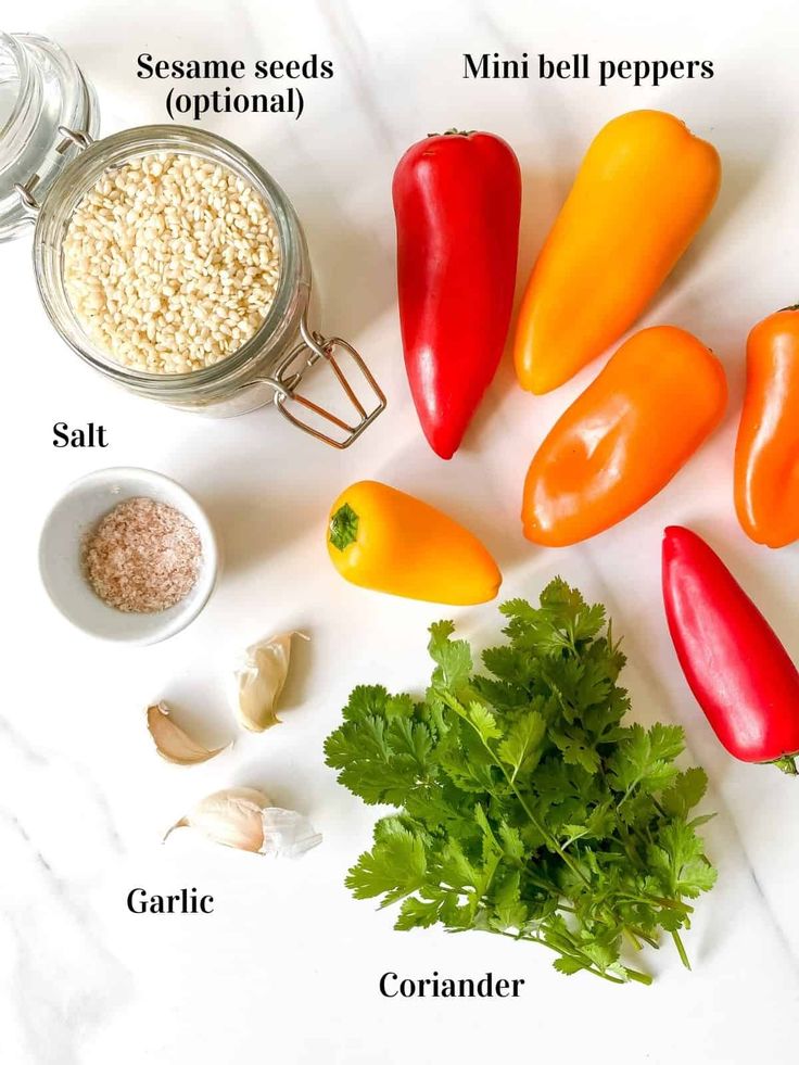 Herb Cream Cheese Stuffed Mini Peppers - Through The Fibro Fog - 10 Crowd-Pleasing Appetizers That Will Wow Your Party | Fresh ingredients: mini bell peppers, coriander, garlic, salt, and optional sesame seeds on a white background.