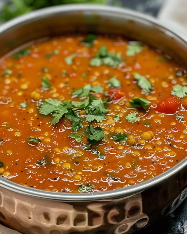 Delicious bowl of spicy lentil curry garnished with fresh cilantro for a hearty meal.