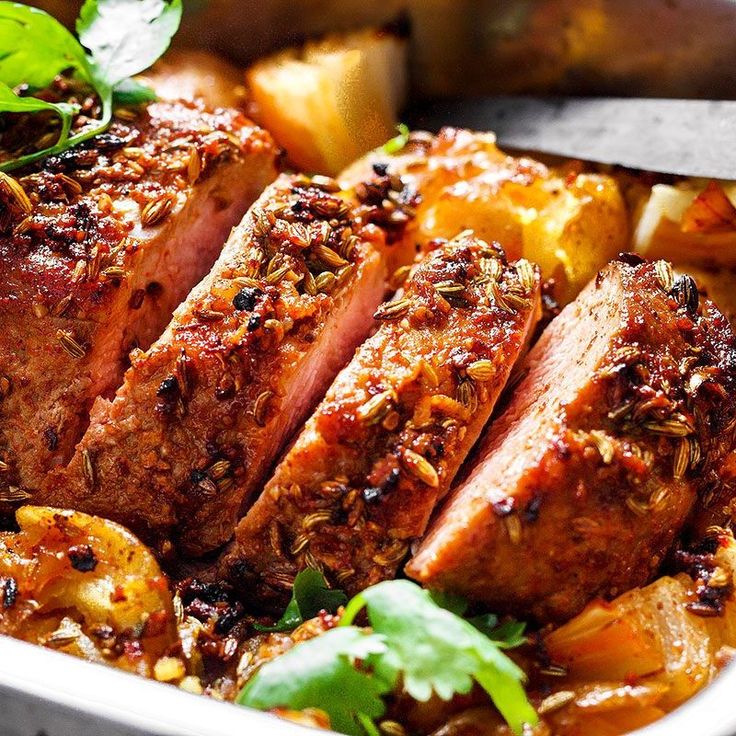 Sliced herb-crusted pork with potatoes and fresh herbs in a flavorful, savory dish.