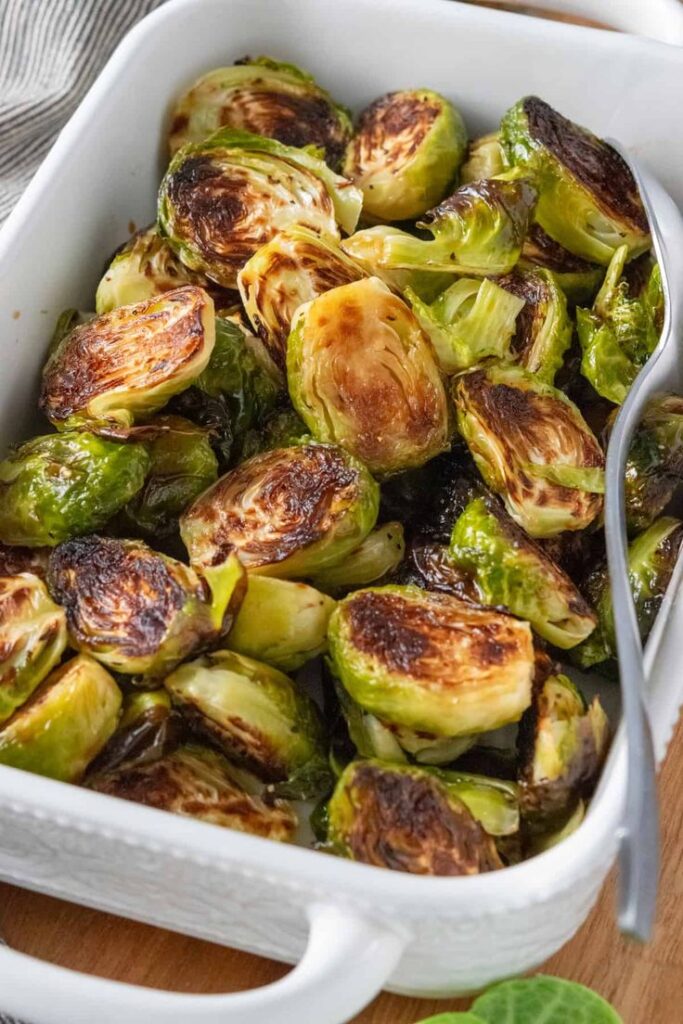 Roasted Brussels sprouts in a white dish, perfectly caramelized and ready to serve.
