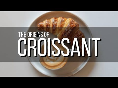 Plate with a croissant and coffee, text overlay reads The Origins of Croissant.