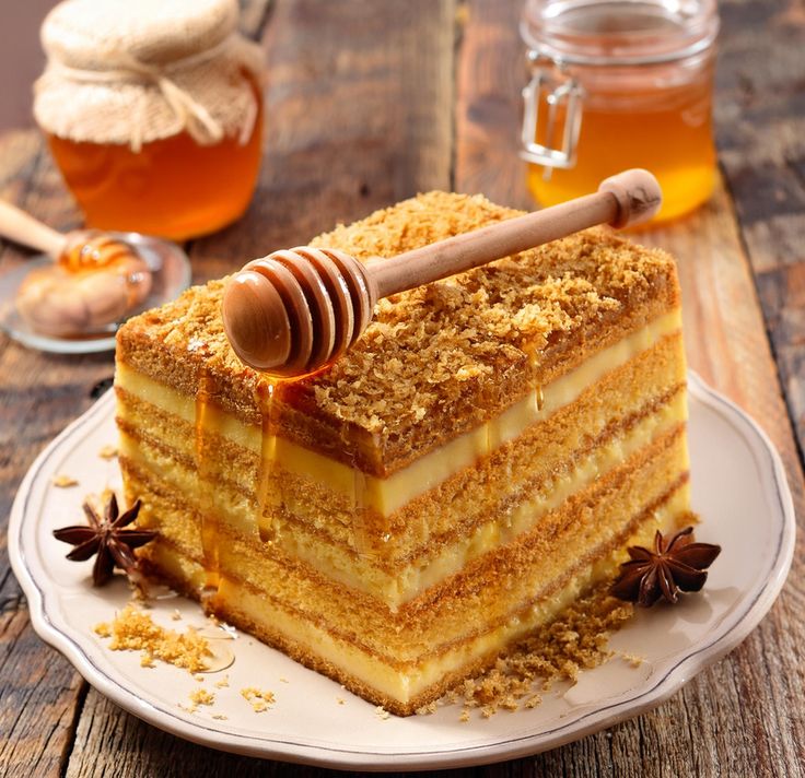 313123f8-6432-4167-804e-c91ec0caab70 - Indulge in Sweet Nostalgia: The Ultimate Homemade Honey Cake Recipe | Delicious honey cake with layered honey drizzle on a rustic wooden table, surrounded by jars of honey and star anise.