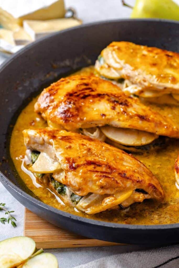 Stuffed chicken breasts with cheese and spinach in a skillet, golden brown and juicy. Perfect for a delicious, healthy meal.