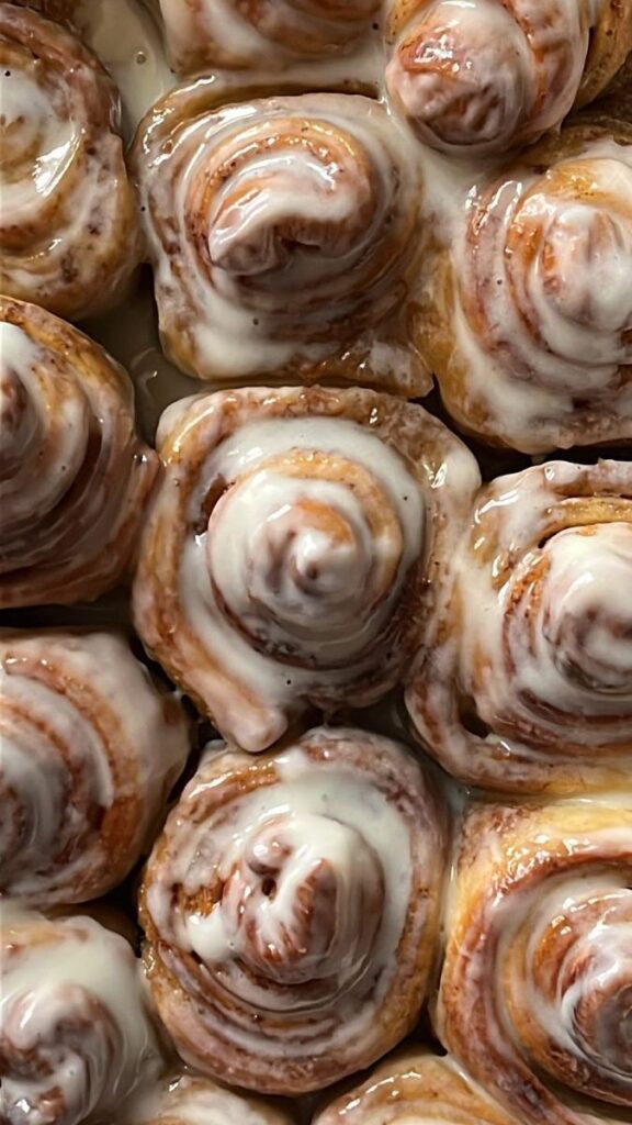 Freshly baked cinnamon rolls drizzled with creamy icing, perfect indulgence for breakfast or dessert.