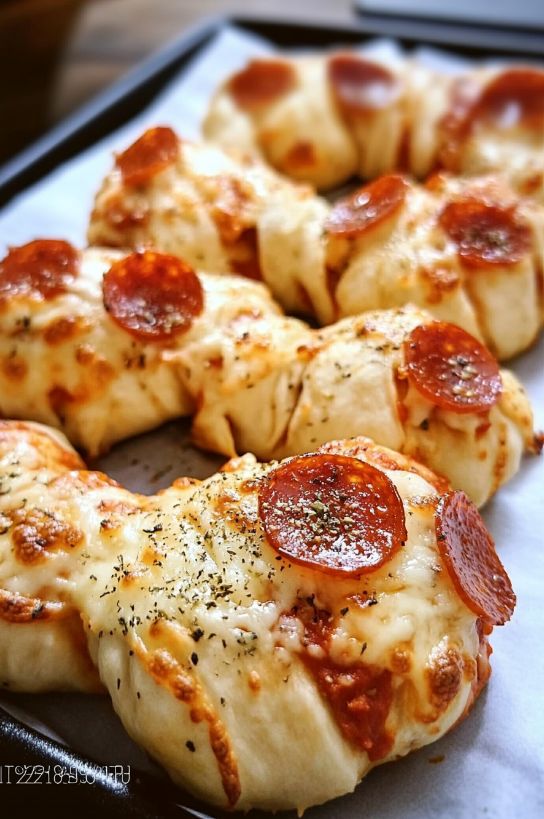 Delicious homemade pepperoni pizza wreath, topped with melted cheese and herbs, fresh out of the oven on a baking sheet.