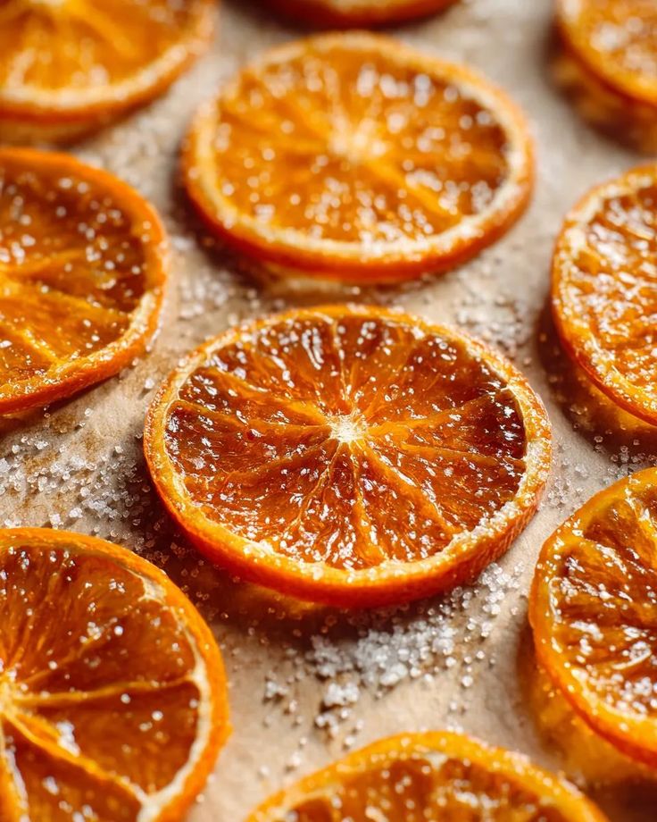 Close-up of sugared orange slices arranged on a baking sheet, perfect for holiday treats or garnish.