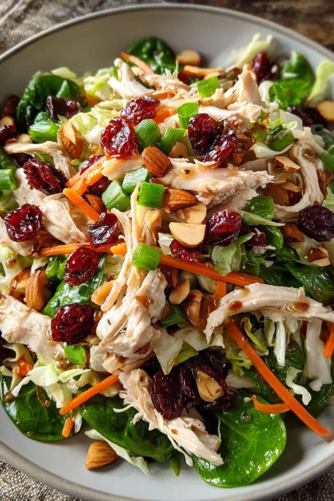 Asian Chicken Cranberry Salad - Make Delicious Chicken Salad with Walnuts & Cheese in Minutes Fresh chicken salad with almonds, cranberries, and greens on a plate, perfect for a healthy meal option.