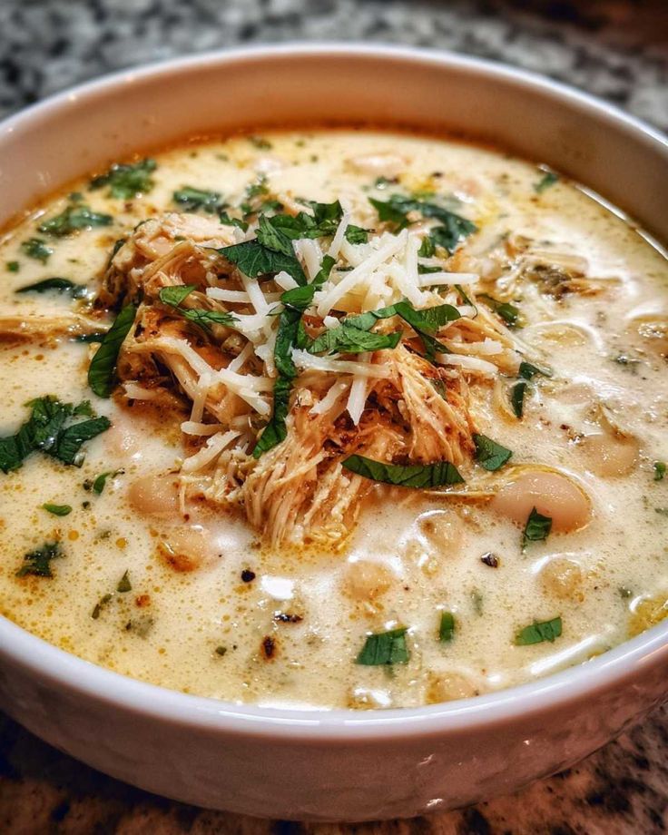 Award-Winning White Chicken Chili_ A Joyful Meal - Flavor Vista - Your Guide to Delicious White Chicken Chili with Easy Tips Hearty chicken and bean soup topped with shredded cheese and fresh herbs in a white bowl.