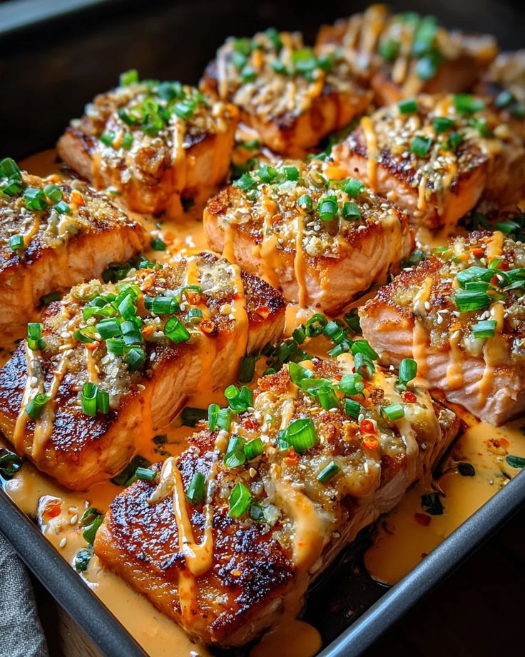 Bang Bang Salmon - Bang Bang Salmon Recipe - Easy & Flavorful Fish Savory baked salmon fillets topped with green onions and sauce in a pan, perfect for a delicious meal. Bang Bang Salmon