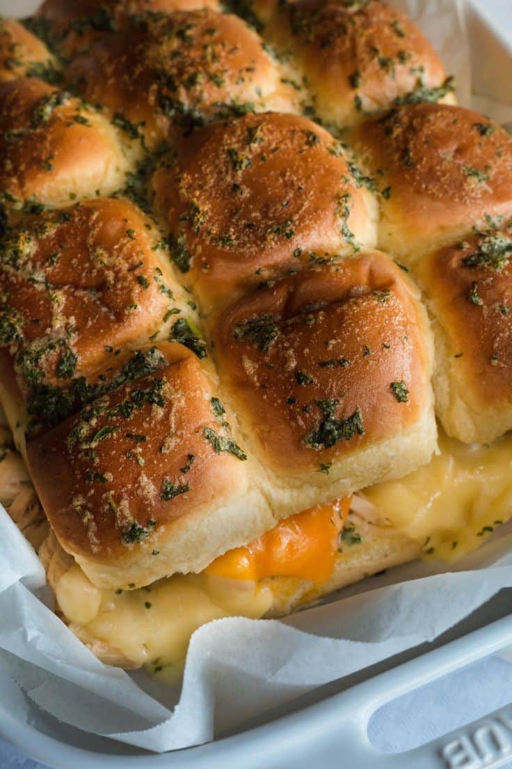 Cheesy garlic slider buns fresh from the oven, topped with herbs and golden brown perfection.