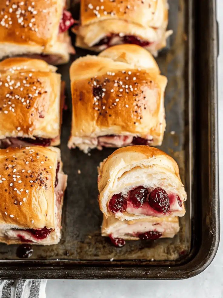 Golden turkey cranberry sliders on a baking sheet, sprinkled with sea salt, fresh from the oven, top view.