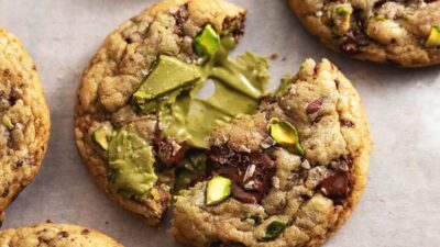 Freshly baked pistachio chocolate cookies with a gooey center, perfect for a sweet and nutty treat.
