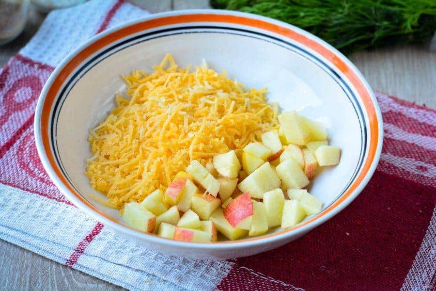 salat_s_kuricei_yablokami_i_orehami-636367 - Make Delicious Chicken Salad with Walnuts & Cheese in Minutes Bowl of shredded cheese and chopped apples on a red and white cloth, ready for a fresh salad.