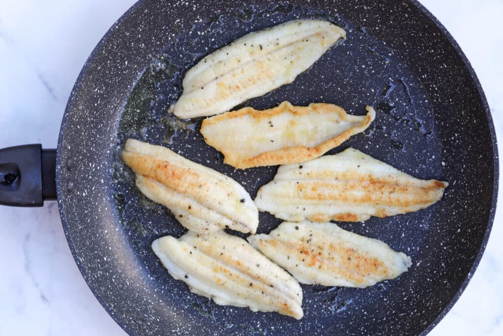 BD2A8772-1-scaled-e1581008788899 - Enjoy a French Favorite: Sole Meunière & Potatoes Pan-fried fish fillets in a non-stick skillet with seasoning.