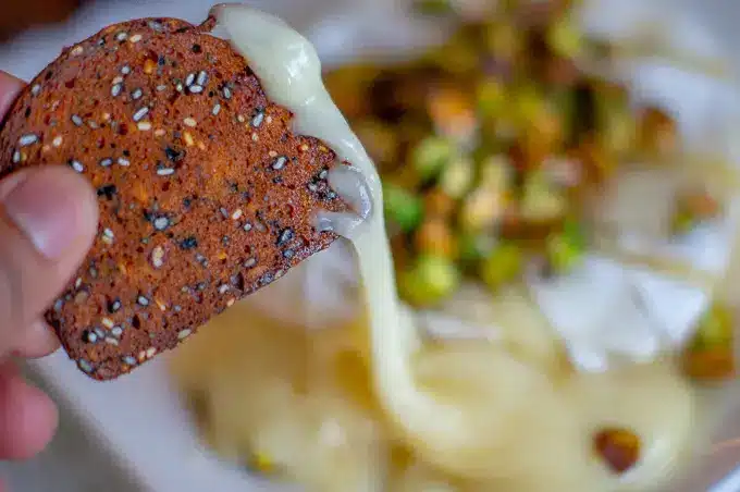 Baked-Brie-with-Honey-Pistachios-5jpg - Melted Brie with Honey & Pistachios in 20 Minutes Crispy seed cracker with melted cheese, topped with pistachios, ready to be served as a delicious appetizer.