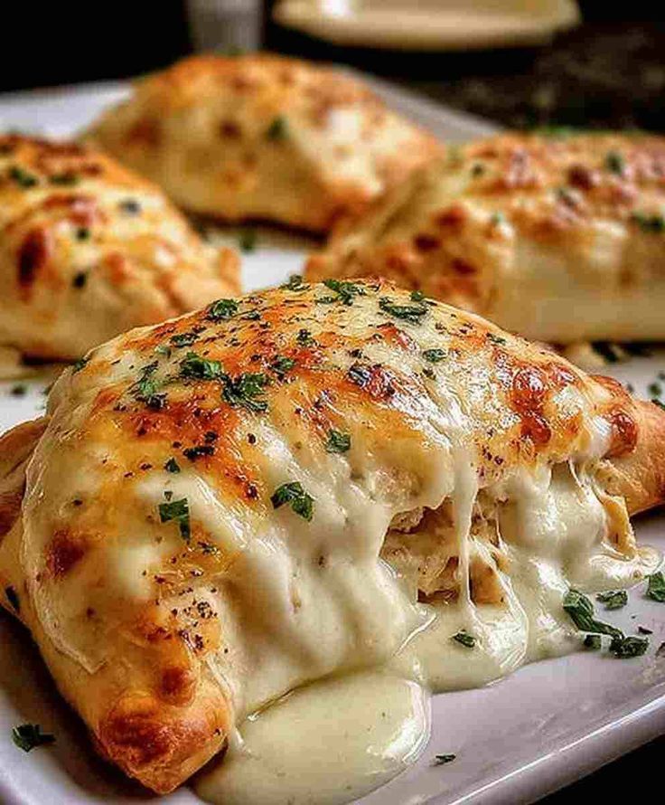 Cheesy baked calzone oozing with filling, garnished with herbs on a plate. Perfect for pizza lovers and Italian cuisine fans.