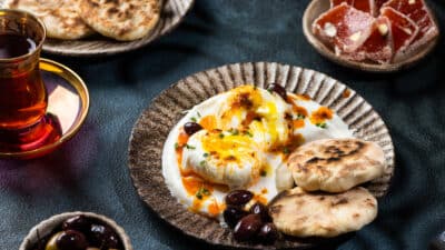 Depositphotos_546727462_S - Master Turkish Eggs: Easy & Delicious Breakfast Recipe Authentic Turkish breakfast with poached eggs, olives, flatbread, and tea.