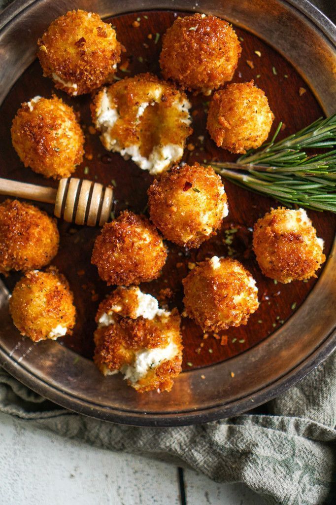 Fried Goat Cheese with Tarragon + Honey - Step-by-Step Guide to Perfect Fried Goat Cheese Balls Crispy goat cheese balls on a plate with honey dipper and rosemary garnish, perfect appetizer or snack.