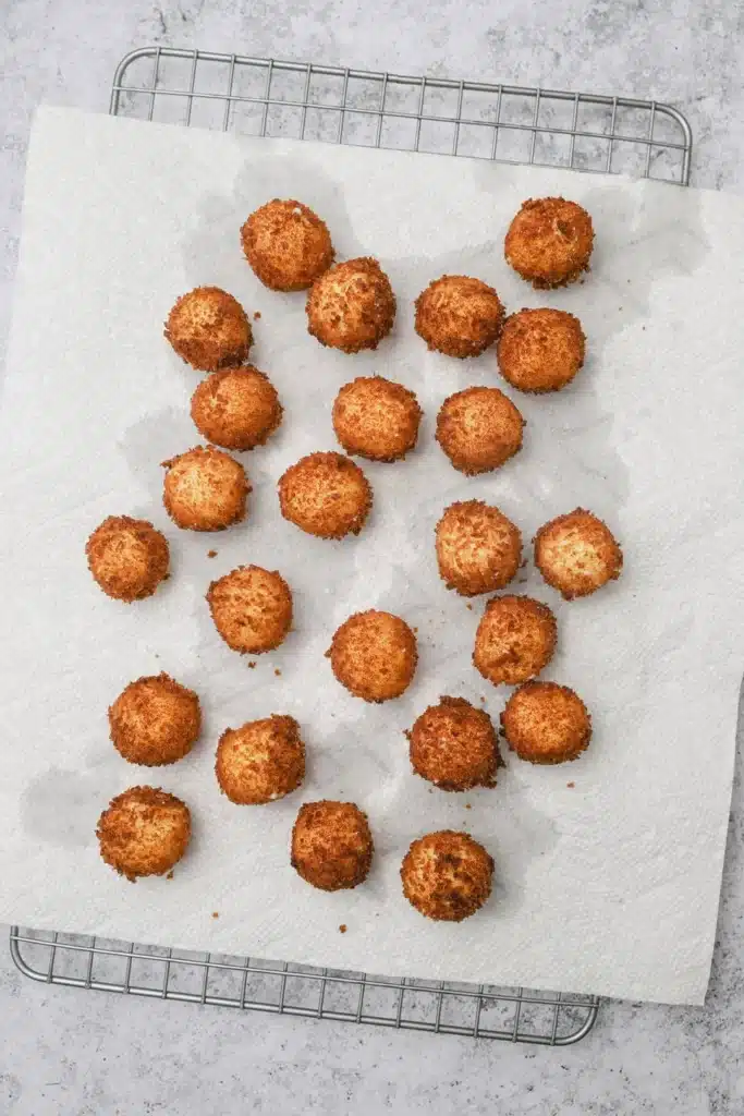 Fried-goat-cheese-balls-7 - Step-by-Step Guide to Perfect Fried Goat Cheese Balls Golden, crispy croquettes cooling on paper towels on a wire rack, perfect for a delicious snack.