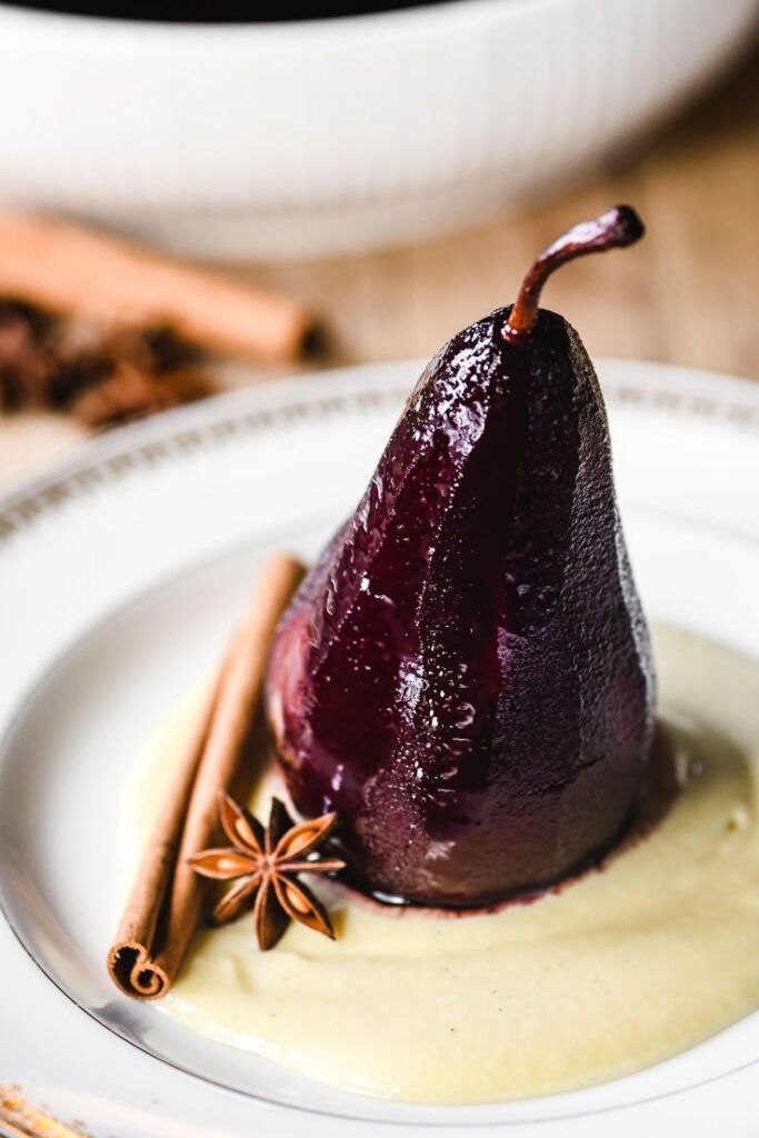 Mulled Red Wine Poached Pears - Elegant Winter Dessert: Perfect Mulled Wine Poached Pears Poached pear in red wine with cinnamon and star anise on a creamy sauce. Perfect dessert for gourmet dining.