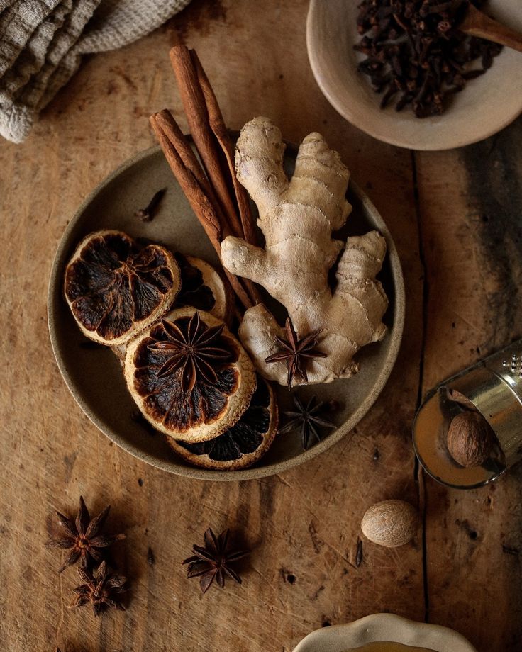 Mulling Spices - Elegant Winter Dessert: Perfect Mulled Wine Poached Pears Rustic spices and dried oranges on a wooden plate, featuring ginger, cinnamon sticks, and star anise.