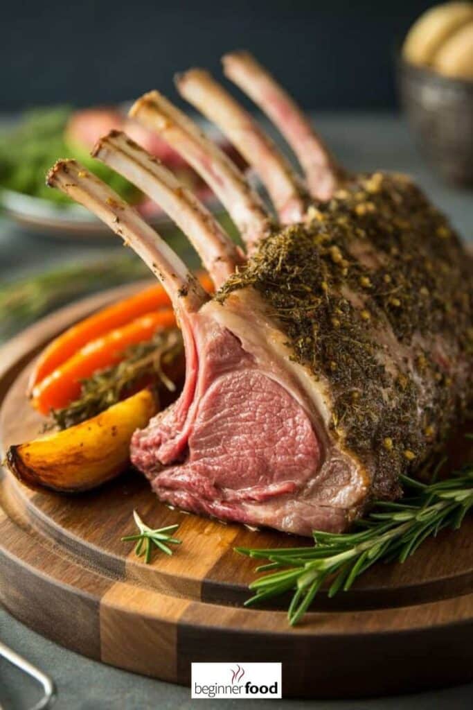 Herb-crusted rack of lamb with roasted vegetables on a wooden platter, garnished with fresh rosemary.