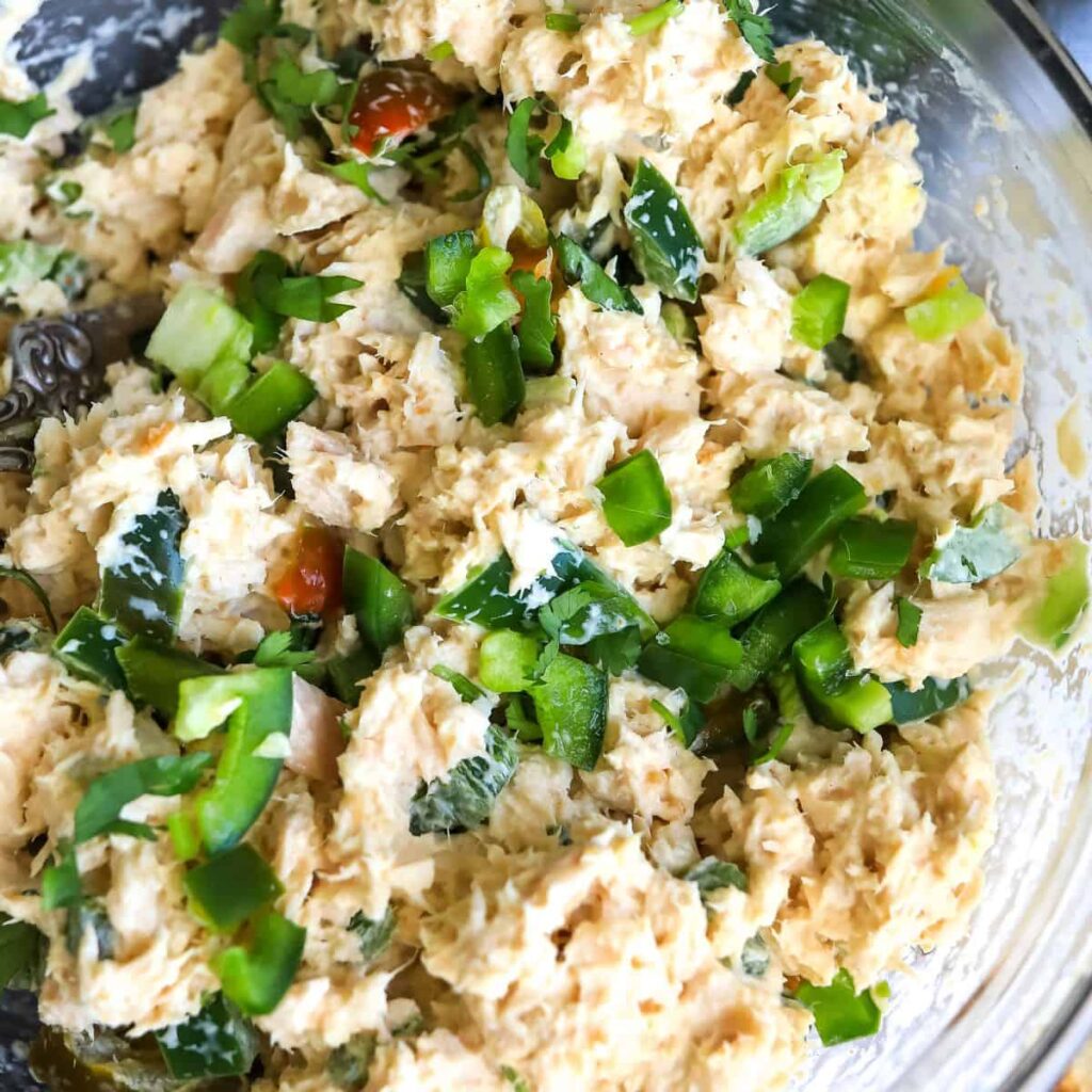 Creamy chicken salad with chopped green bell peppers, served in a glass bowl, perfect for a fresh and tasty meal.